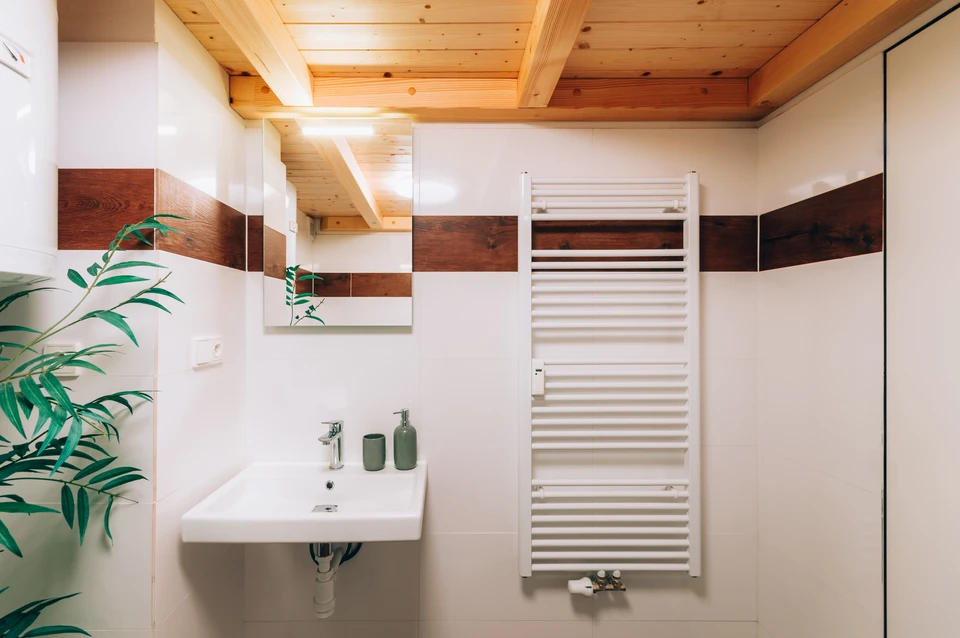 Salle de bain moderne avec lavabo suspendu blanc, robinetterie chromée et accessoires verts