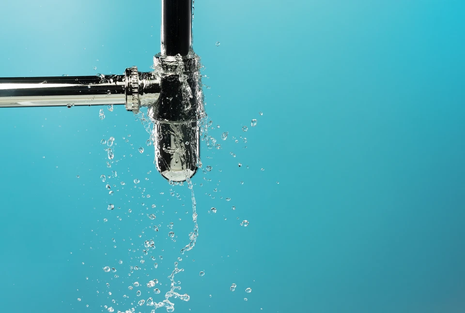 Intérieur résidentiel avec personne tenant un smartphone affichant une application de détection d'eau